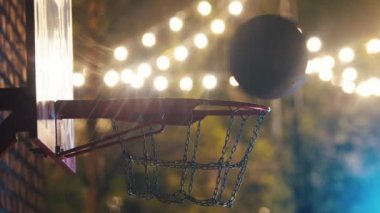 Basketbol topu dışarıda oyun sahasında potaya giriyor.