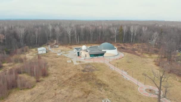 Observatório de pesquisa no meio do campo cercado por árvores nuas — Vídeo de Stock