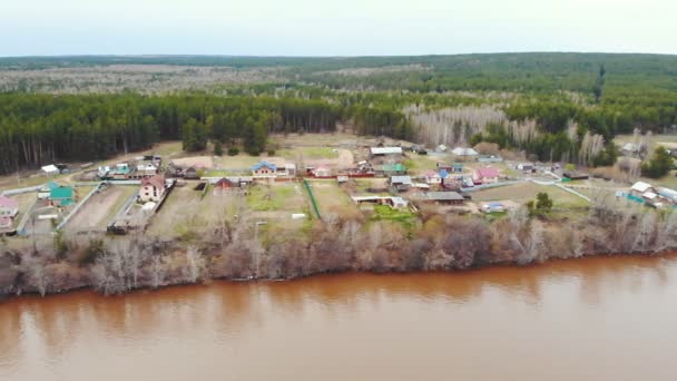 靠近森林的棕褐色脏河沿岸的工业村 — 图库视频影像