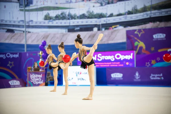 12-03-2020 KAZAN, RUSSIE : adolescentes en costumes rouges jouant avec des balles sur le tournoi de gymnastique — Photo