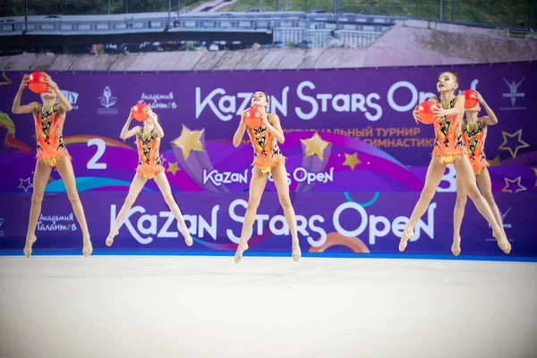 12-03-2020 RUSSIA, KAZAN: 10 대소녀 체조 선수들이 밝은 의상을 입고 체조 토너먼트에서 공을 가지고 숫자를 연기하는 모습 — 스톡 사진