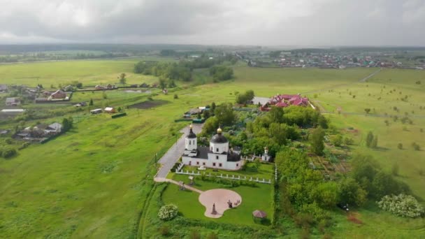 Russisches Dorf und Kirche mit schwarzen Kuppeln im Regen — Stockvideo