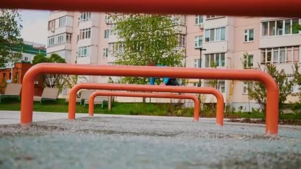 Um garotinho brincando no playground pulando sobre os obstáculos — Vídeo de Stock