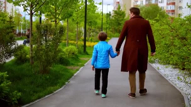 Jovem e seu irmãozinho andando no parque e passando tempo juntos — Vídeo de Stock