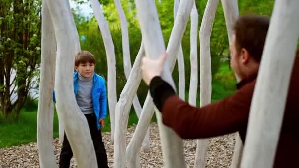 Glad ung man och hans lillebror leker ikapp i parken och umgås — Stockvideo