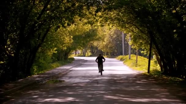 Jongeman op een fiets met zijn handen uit elkaar — Stockvideo