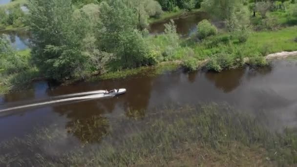 Man op een motorboot drijvend op een kleine modderige rivier — Stockvideo