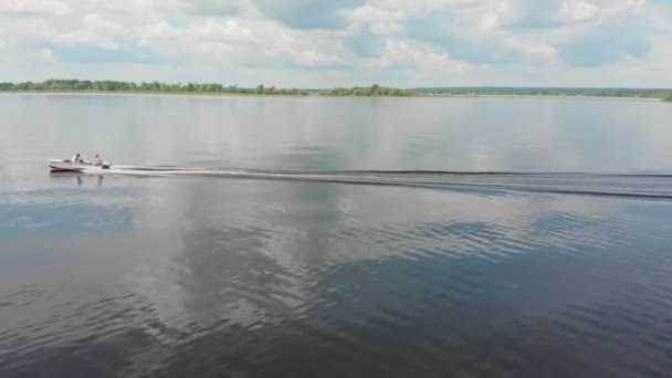 Twee mannen paardrijden motorboot op rivier - groene eilanden op het water — Stockvideo