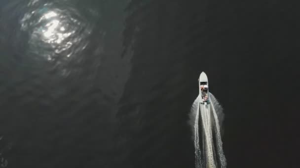 Люди ездят на моторной лодке по темной реке — стоковое видео