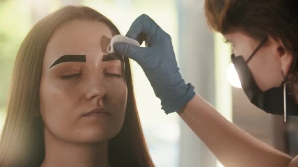 Cosmetoloog wist de getinte kleur van de wenkbrauw van een jonge vrouw — Stockvideo