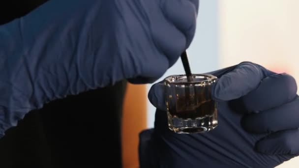 Mestre Brow amassa a tintura de sobrancelha em um pequeno recipiente de vidro — Vídeo de Stock