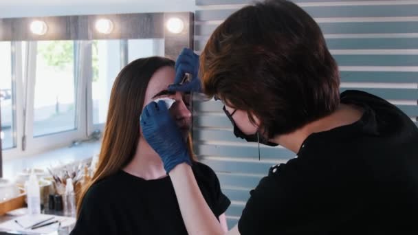 Il maestro sopracciglio pulisce la tintura per capelli scura con un batuffolo di cotone — Video Stock