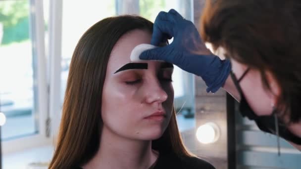 Brow master mulai menyeka dari pewarna rambut alis dengan pad kapas — Stok Video