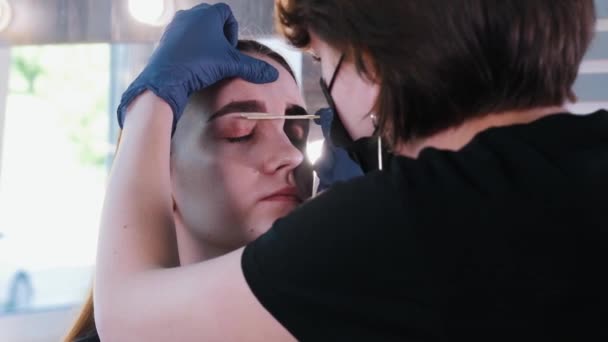 Brow master nanášení žlutého vosku na obočí kosti mladé ženy — Stock video