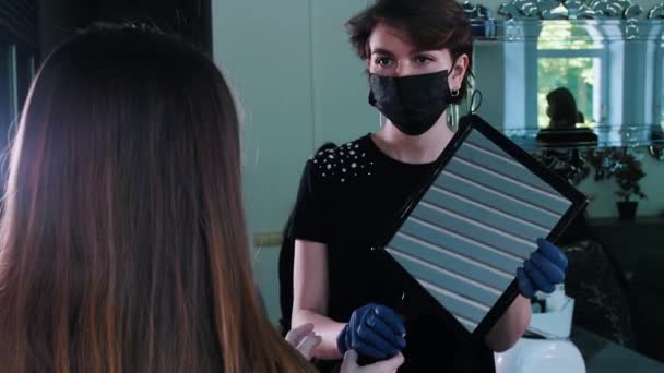 Mujer joven en el estudio mirando al espejo después de teñir la frente — Vídeos de Stock