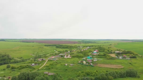 Verde campo aperto e un villaggio — Video Stock