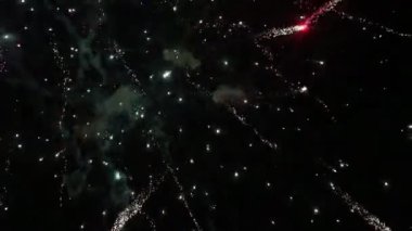 Geceleri gökyüzünde farklı renkte parlak havai fişekler patlıyor. Gökyüzü dumanla doluyor.
