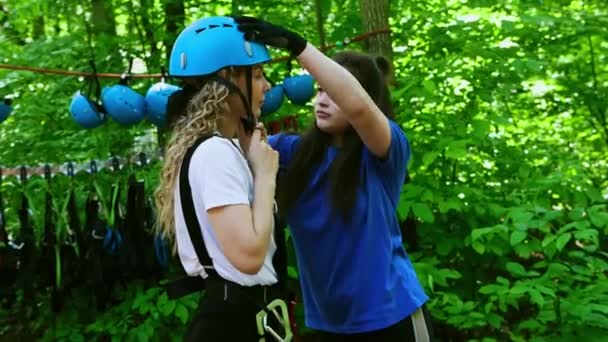 Kötél kaland - egy női oktató felveszi a biztosítási sisakot egy fiatal nő fejére — Stock videók