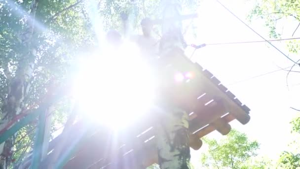 Touw avontuur - vrouw en man staan op de hangbrug en zwaaien handen — Stockvideo