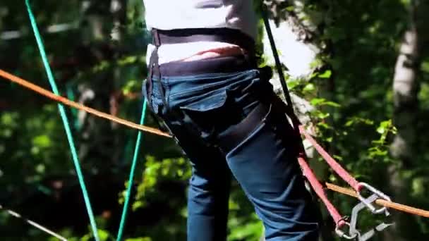 Avventura corda - l'uomo cammina con attenzione sul ponte di corda sospesa tenendo la corda superiore con le mani — Video Stock