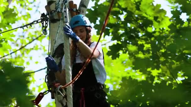 Lano dobrodružství - usmívající se žena pohybující se z jedné oblasti do druhé drží lano — Stock video