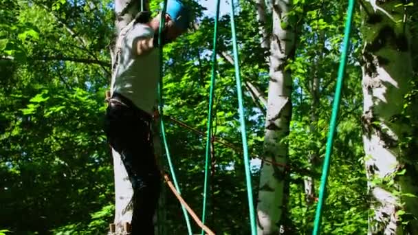 Kötél kaland - férfi tetoválás óvatosan sétál a felfüggesztő kötél híd — Stock videók