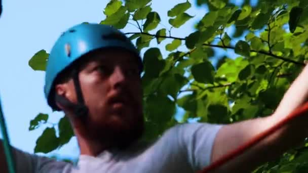 Seil-Abenteuer - Mann mit Tätowierung läuft auf dem Seil, das sich mit den Händen am oberen Seil hält — Stockvideo