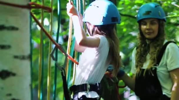 Touw avontuur - een klein meisje bewegen over de touw muur en haar moeder staat achter haar — Stockvideo