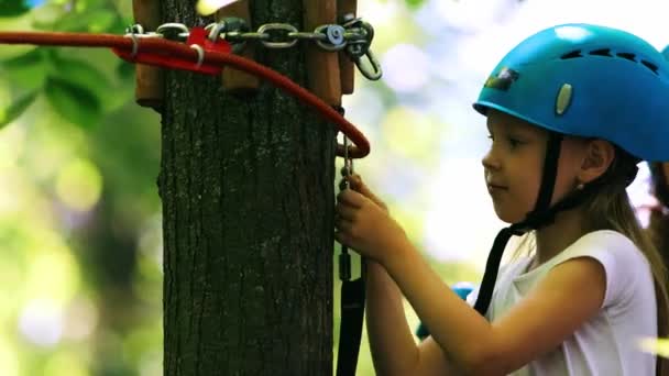 Веревочное приключение - маленькая девочка и ее мать движутся по веревочному мосту — стоковое видео