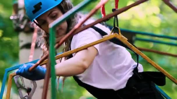 Estrema avventura di corda nel parco - una donna con protezione che si muove sul ponte di corda — Video Stock