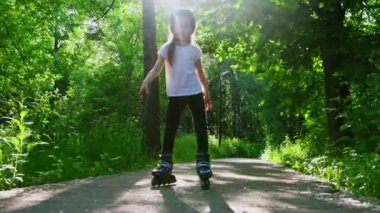 Parkta patenleriyle kayan küçük bir kız.