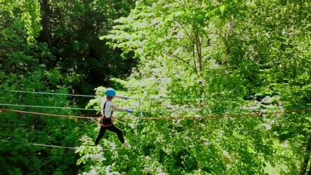 Extrém kötél kaland a parkban - nő sétál a kötélen, hogy a stand a biztosítással — Stock videók