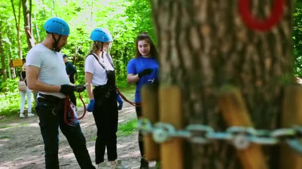 Touw avontuur - instructeur uit te leggen aan paar hoe ze hun verzekeringsgordels te gebruiken — Stockvideo