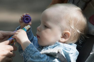 Küçük bebek dışarıda bebek arabasında oturuyor