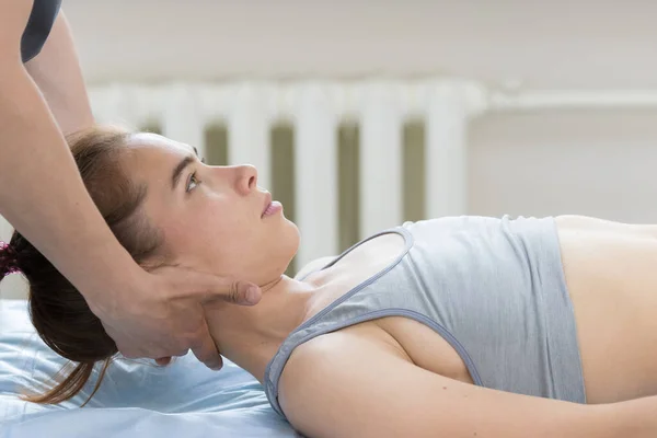 Остеопатическое лечение - мастер кладет голову молодой женщины на подушку — стоковое фото