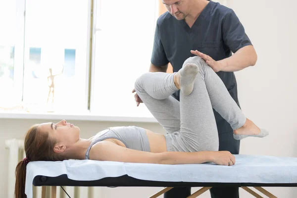 Młoda kobieta poddawana leczeniu osteopatii - mistrz naciska na nogi — Zdjęcie stockowe