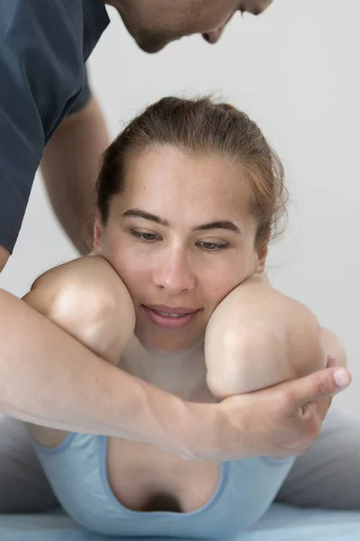 Mulher jovem que tem tratamento de osteopatia na clínica - deitada na pose com os cotovelos para a frente — Fotografia de Stock