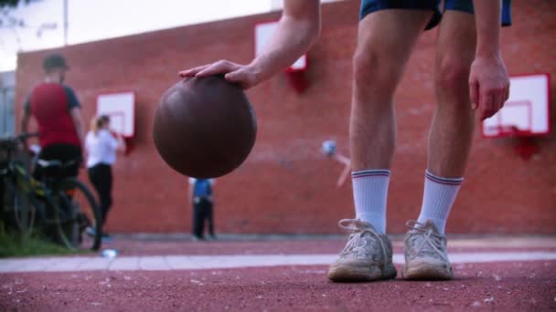 Muž na basketbalovém hřišti bít míč ze země — Stock video