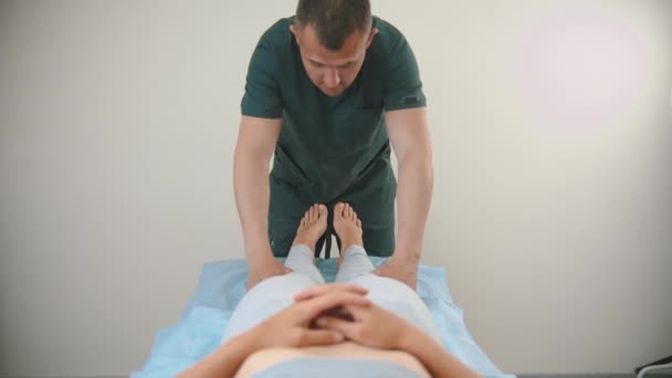 Woman having an osteopath treatment - the doctor working with her feet — Stock Video