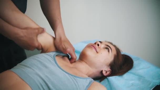 Žena podstupující osteopatickou léčbu - lékař jí masíruje rameno — Stock video