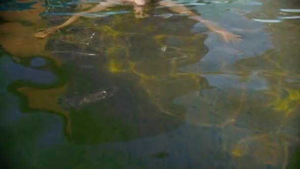 Молодой человек плавает в бассейне — стоковое видео