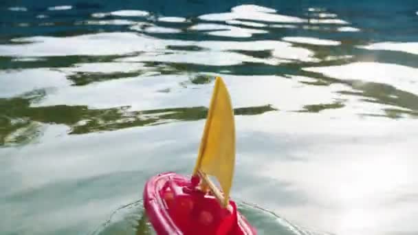 Ein kleines Spielzeugschiff segelt im Pool — Stockvideo