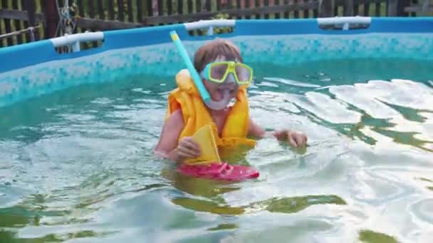 一个小男孩带着水下面具在充气游泳池里游泳 — 图库视频影像