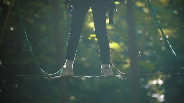 Una mujer caminando sobre la cuerda - una atracción de entretenimiento en el bosque — Vídeo de stock