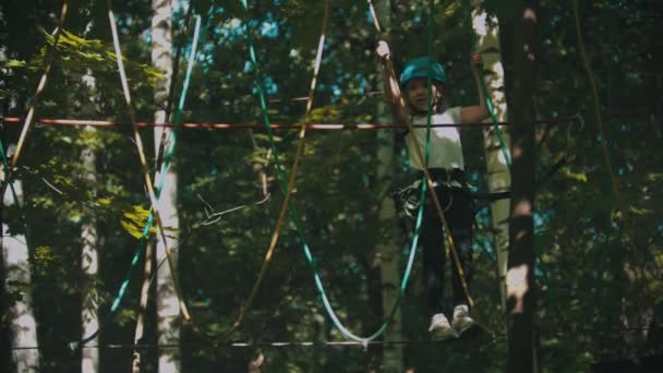 Une petite fille marchant sur la corde - une attraction de divertissement dans la forêt — Video