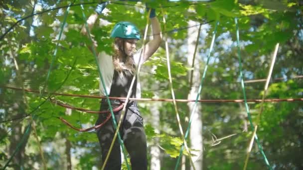 Szőke nő sétál a kötélen - szórakoztató attrakció a zöld erdőben — Stock videók