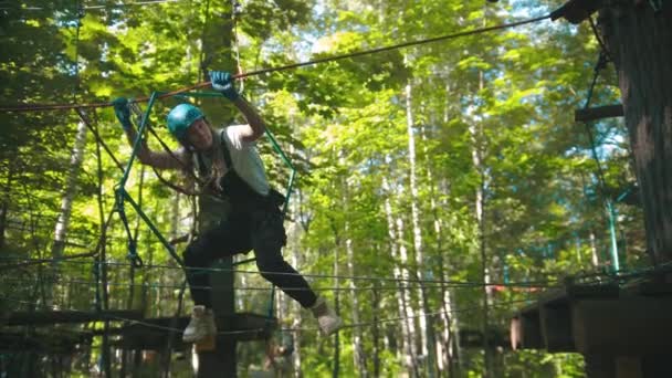 Mulher cruzando uma corda - uma atração de entretenimento na floresta para jovens — Vídeo de Stock