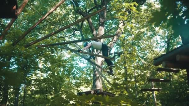 Un homme traversant la construction de cordes dans la forêt - attraction extrême — Video