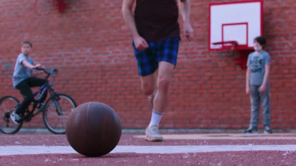 Jeune homme sur le terrain de basket-ball courir après le ballon — Video