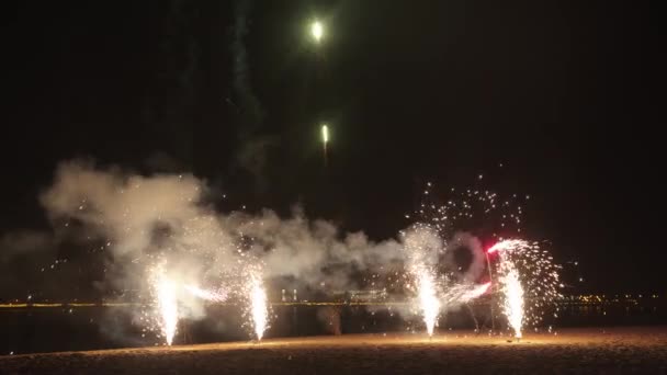 Explosion de feux d'artifice sur la plage la nuit - mouvements de rotation et explosion vers le haut — Video